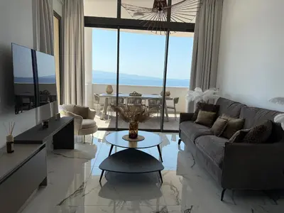 a living room with a couch and a table at Appartement de luxe type 4 Eden Suite Sanguinaires vue mer avec piscine chauffée résidence Ajaccio in Ajaccio