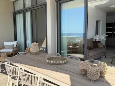 a dining room table with chairs and a couch at Appartement de luxe type 4 Eden Suite Sanguinaires vue mer avec piscine chauffée résidence Ajaccio in Ajaccio