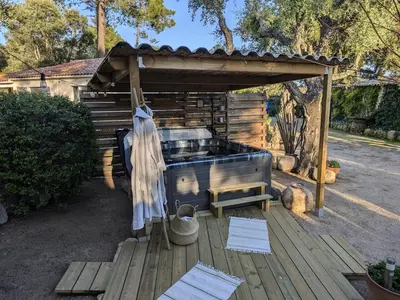 a hot tub on a wooden deck with a wooden structure at L'Attellu Di Babbu pour 2 in Lecci
