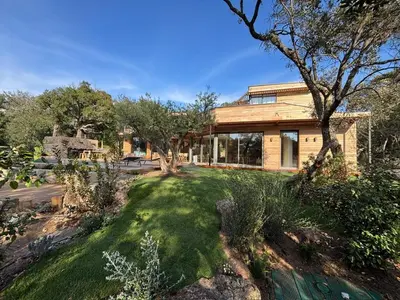 a house with a grassy yard in front of it at Villa L'Immortelle in Lecci
