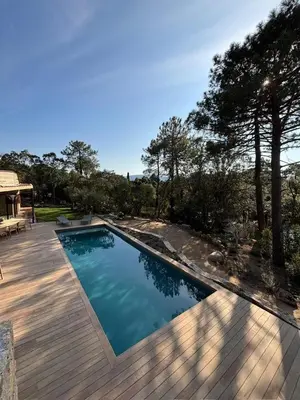 a swimming pool with a wooden deck at Villa L'Immortelle in Lecci