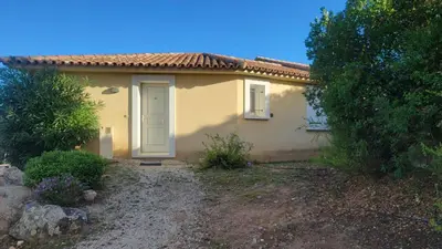 a small yellow house with a white door at Villa Résidence San Martinu Sainte Lucie De Porto Vecchio in Zonza