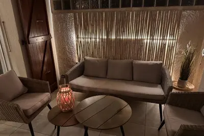 a living room with a couch and a table at Le Yucca - Vue mer 100 m de la plage in Pietrosella