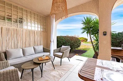 a living room with a couch and a table at Le Yucca - Vue mer 100 m de la plage in Pietrosella