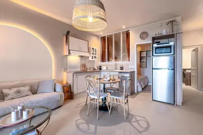 a kitchen and a living room with a table and chairs at Le Yucca - Vue mer 100 m de la plage in Pietrosella
