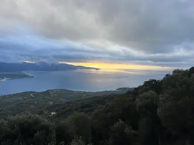 a view of a body of water with the sun setting at Maison avec vue imprenable in Olmeto