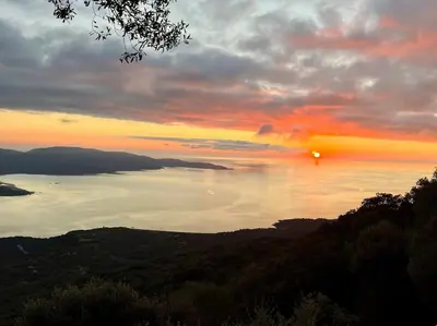 a sunset over a body of water with the sun setting at Maison avec vue imprenable in Olmeto