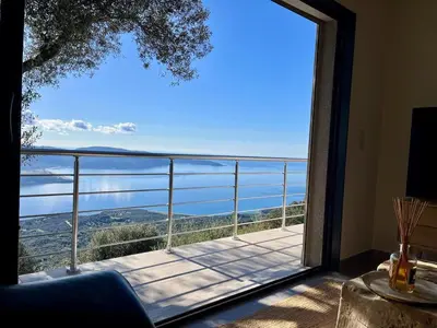 a view of the ocean from a balcony at Maison avec vue imprenable in Olmeto