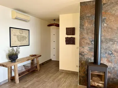 a living room with a fireplace and a wooden table at Maison avec vue imprenable in Olmeto