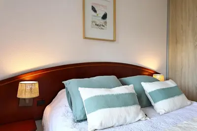 a bed with towels on it in a room at Les Sanguinaires N'7 - T2 Vue Mer, Piscine & Plage in Ajaccio