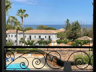 a balcony with a view of a pool and buildings at Appartement T2 vue mer, piscine Linguizzetta Bravone in Linguizzetta