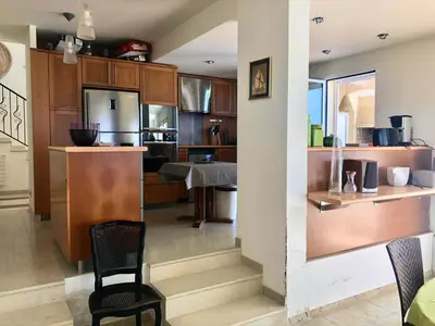 a kitchen with wooden cabinets and a table and a chair at Casamea - Sagone, Villa Vue Mer, Clim, Piscine in Coggia
