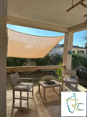 two chairs and a hammock on a patio at villa avec jacuzzi privé proche plage in Solaro