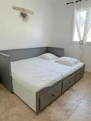 a bed in a white room with a window at villa avec jacuzzi privé proche plage in Solaro
