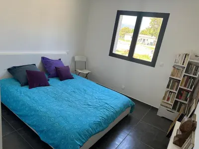 a bedroom with a bed with blue sheets and a window at Villa avec piscine privée Santa Maria Poggio in Santa-Maria-Poggio