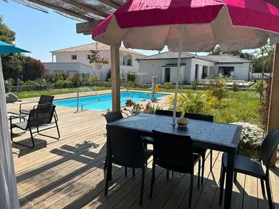 a patio with a table and chairs and an umbrella at Villa avec piscine privée Santa Maria Poggio in Santa-Maria-Poggio