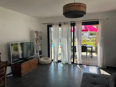 a living room with a tv and a sliding glass door at Villa avec piscine privée Santa Maria Poggio in Santa-Maria-Poggio