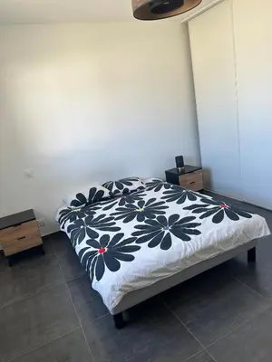 a bedroom with a bed with a black and white blanket at Villa avec piscine privée Santa Maria Poggio in Santa-Maria-Poggio