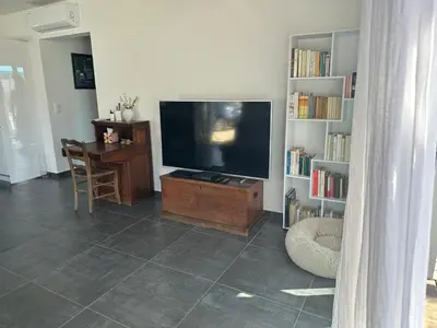 a living room with a flat screen tv and a book shelf at Villa avec piscine privée Santa Maria Poggio in Santa-Maria-Poggio