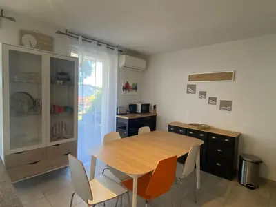 a dining room with a wooden table and chairs at A LAVANDA Maison BONIFACIO in Bonifacio