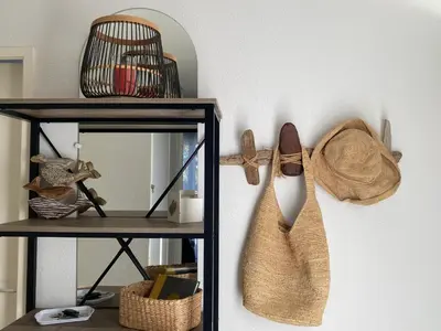 a shelf with a hat and shoes hanging on a wall at A LAVANDA Maison BONIFACIO in Bonifacio