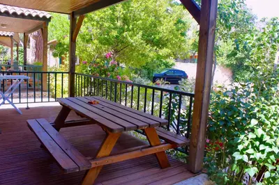 a wooden picnic table sitting on a wooden deck at Résidence L'araguina in Bonifacio
