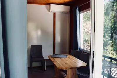 a room with a wooden table and chairs and a window at Résidence L'araguina in Bonifacio