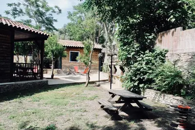 a wooden picnic table in a yard next to a building at Résidence L'araguina in Bonifacio