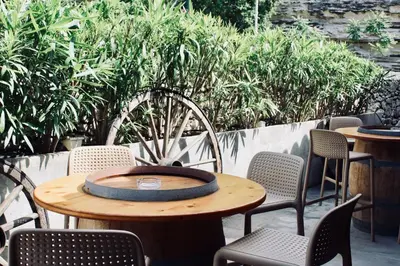 a wooden table with chairs and a clock on it at Résidence L'araguina in Bonifacio