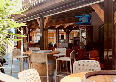 a restaurant with tables and chairs and a tv at Résidence L'araguina in Bonifacio