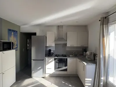 a kitchen with white appliances and a large window at Mini-villa 1 in Bonifacio