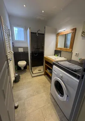 a bathroom with a washing machine and a sink at Mini-villa 1 in Bonifacio
