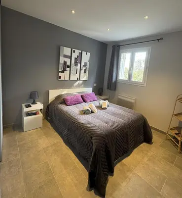 a bedroom with a large bed with purple pillows at Mini-villa 1 in Bonifacio