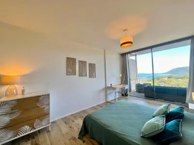 a bedroom with a bed and a large window at Loft Centre-Ville Vue Mer in Porto-Vecchio