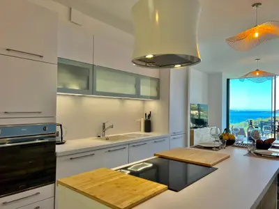 a kitchen with white cabinets and a large window at Loft Centre-Ville Vue Mer in Porto-Vecchio