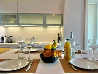 a kitchen with a table with plates and wine glasses at Loft Centre-Ville Vue Mer in Porto-Vecchio