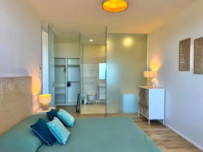a bedroom with a large bed and a mirror at Loft Centre-Ville Vue Mer in Porto-Vecchio