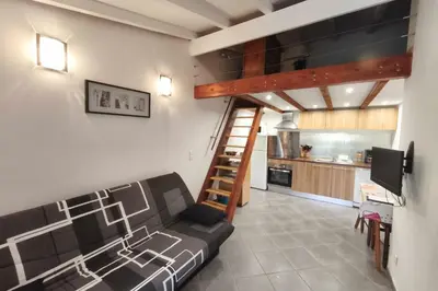 a living room with a couch and a kitchen at Beautiful T2 in residence with swimming pools in Grosseto-Prugna