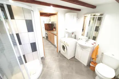a bathroom with a toilet sink and a washing machine at Beautiful T2 in residence with swimming pools in Grosseto-Prugna