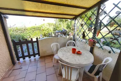 a room with a table and chairs on a balcony at Beautiful T2 in residence with swimming pools in Grosseto-Prugna