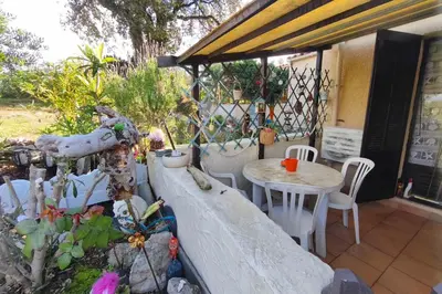 a patio with a table and chairs and a fence at Beautiful T2 in residence with swimming pools in Grosseto-Prugna