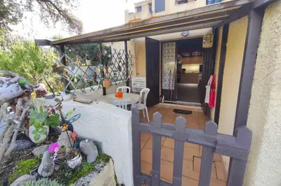 a porch of a house with a wooden fence at Beautiful T2 in residence with swimming pools in Grosseto-Prugna