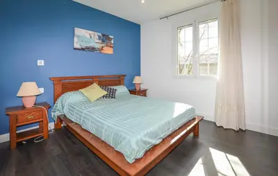a bedroom with a bed with a blue wall at Gorgeous Home In Cervione With Wifi in Cervione
