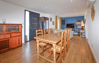 a kitchen and dining room with a wooden table and chairs at Gorgeous Home In Cervione With Wifi in Cervione