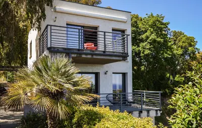 a building with a balcony and a palm tree at 2 Bedroom Lovely Home In Cervione in Cervione