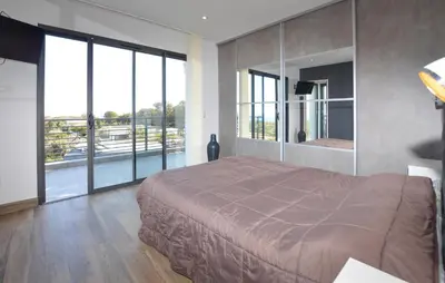 a bedroom with a large bed and large windows at 2 Bedroom Lovely Home In Cervione in Cervione