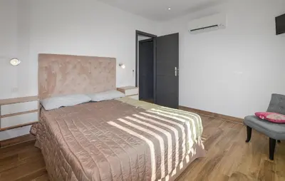 a bedroom with a large bed and a chair at 2 Bedroom Lovely Home In Cervione in Cervione