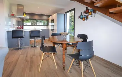 a kitchen and dining room with a wooden table and chairs at 2 Bedroom Lovely Home In Cervione in Cervione