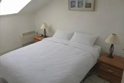 a bedroom with a large white bed with two lamps at Les Marines de Moriani in San-Nicolao