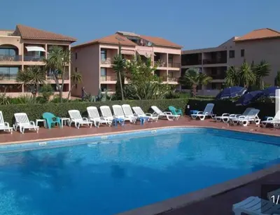 a swimming pool with lounge chairs and a hotel at Les Marines de Moriani in San-Nicolao